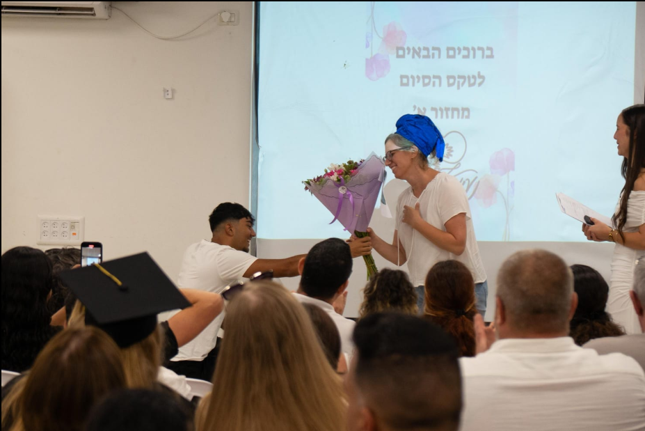 בוגרי המחזור הראשון על הבמה עם גלימות